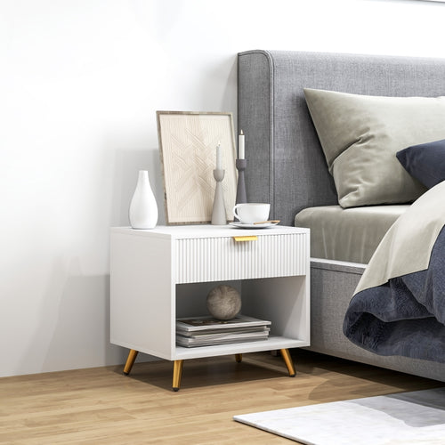 White bedside table with gold-tone legs beside a bed