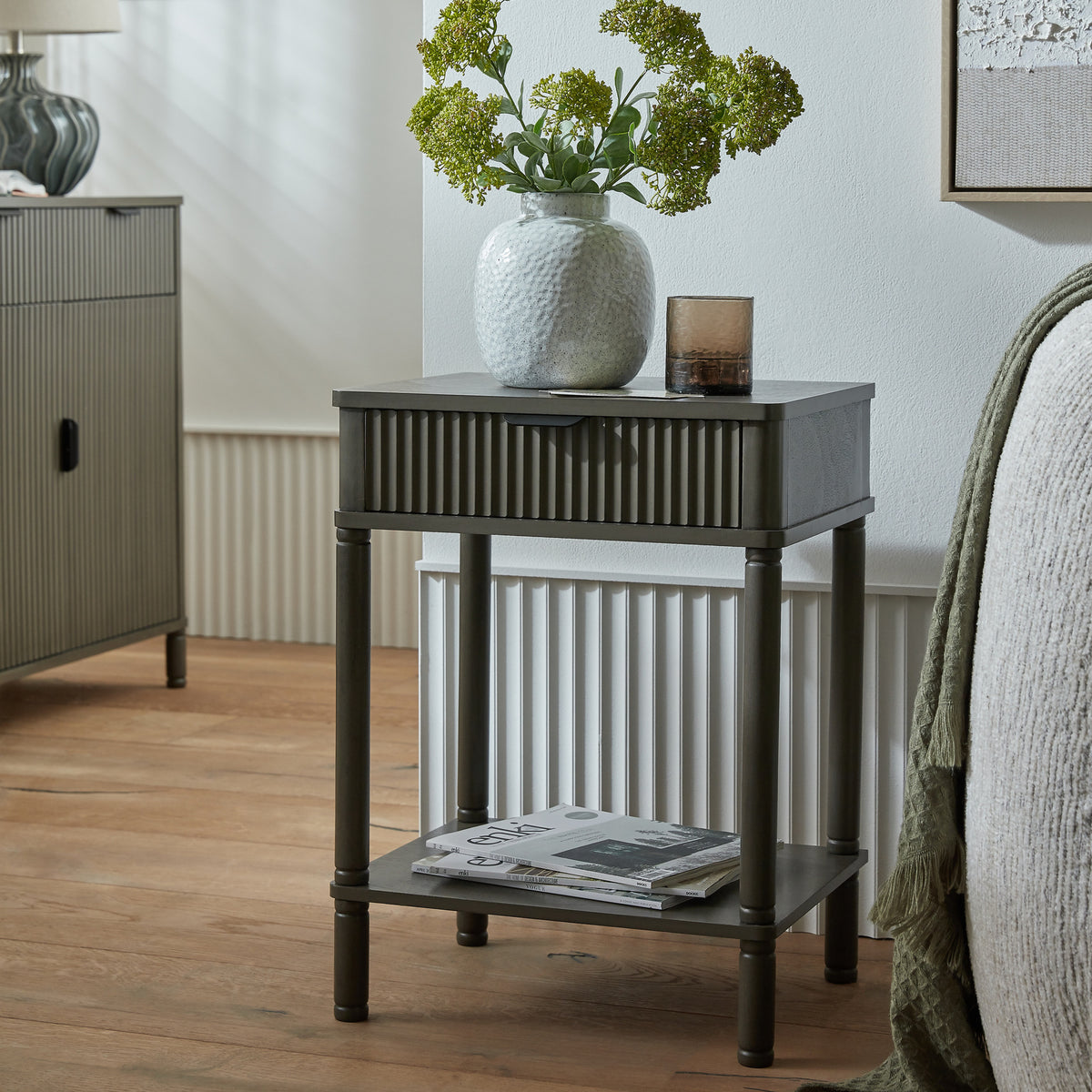 Reed side table styled beside a bed