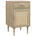 Natural wood bedside cabinet with top drawer, rattan door and tapered legs on a white background