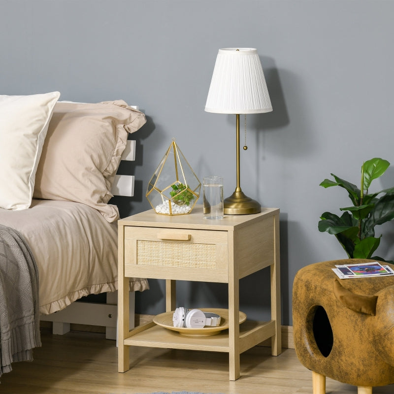Bedside table with rattan drawer front next to a bed with a table lamp