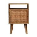 Light oak-tone bedside cabinet with a woven rattan door and an open cubby above, on four tapered legs, front view