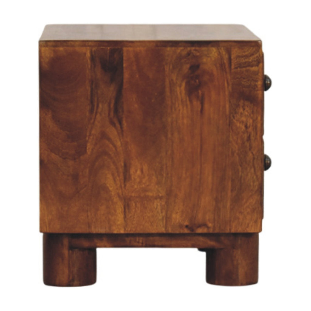 Side view of the chestnut bedside table with two thick round block legs and the knobs visible at the edge