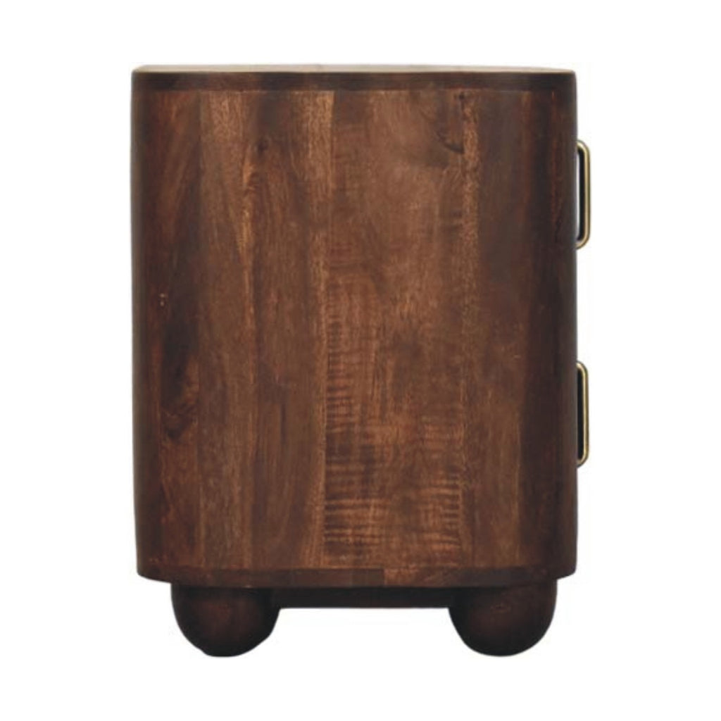 Side view of the dark walnut-brown bedside table with rounded ends, two brass handles at the edge and ball feet