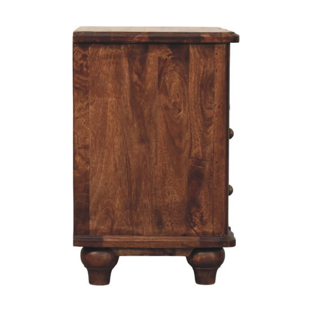 Side view of the brown bedside table with plain side panel, knobs at the edge and turned feet