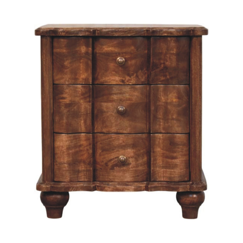Three-drawer bedside table with wavy panelled drawer fronts, brass knobs and turned feet, front view