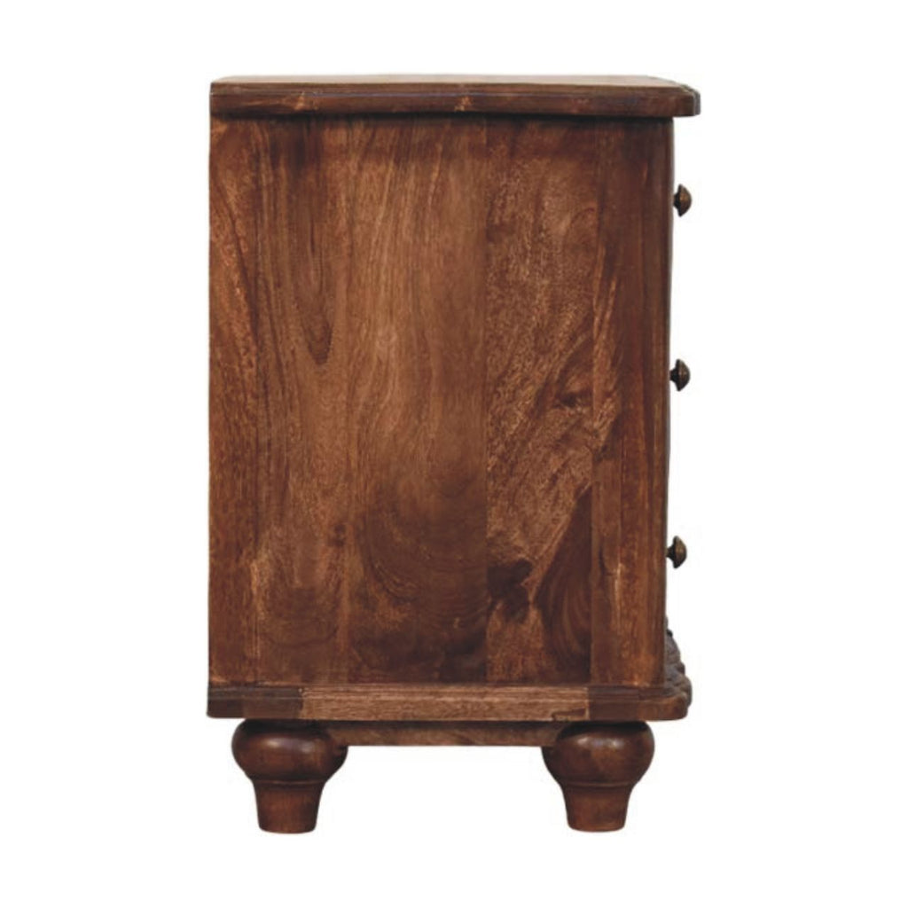 Side view of the brown three-drawer bedside table with plain side panel, knobs at the edge and turned feet