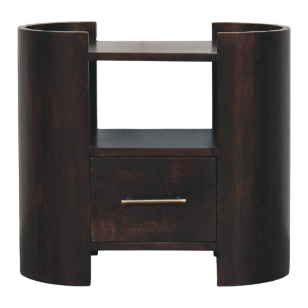Wide dark bedside table in dark mango wood, front view with curved side columns, open shelf and one drawer