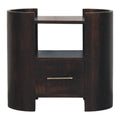 Wide dark bedside table in dark mango wood, front view with curved side columns, open shelf and one drawer