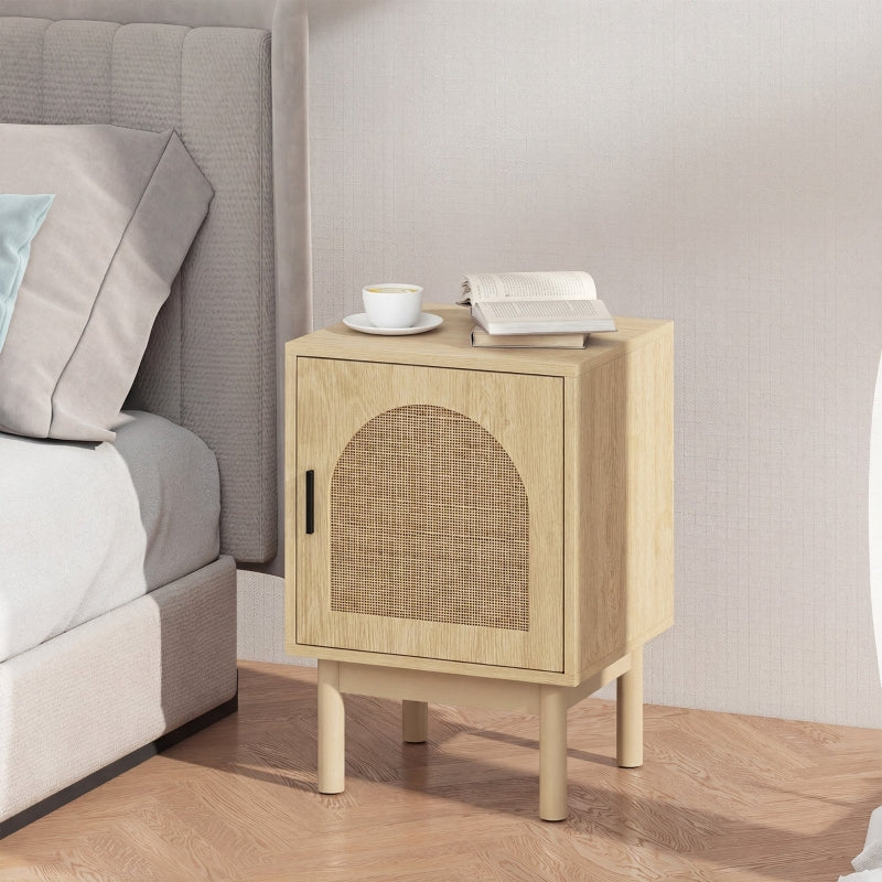 Arched rattan bedside table next to a grey bed with a cup and book