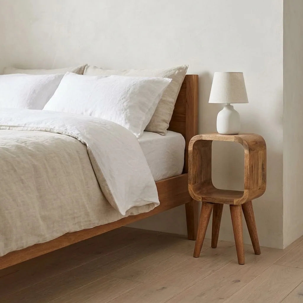 Eden 20 cm Open Bedside Table beside a bed with linen bedding, with a table lamp on top