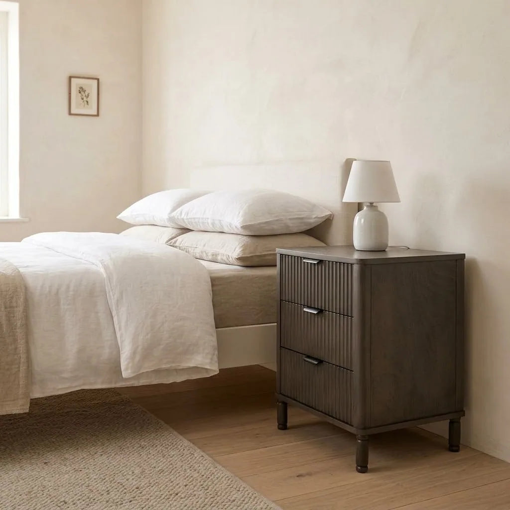 Hamble 45 cm Fluted Bedside Table beside a bed with linen bedding, with a table lamp on top