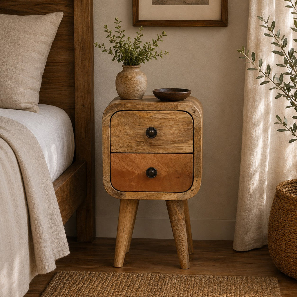 Light narrow bedside table with 2 drawers beside a bed