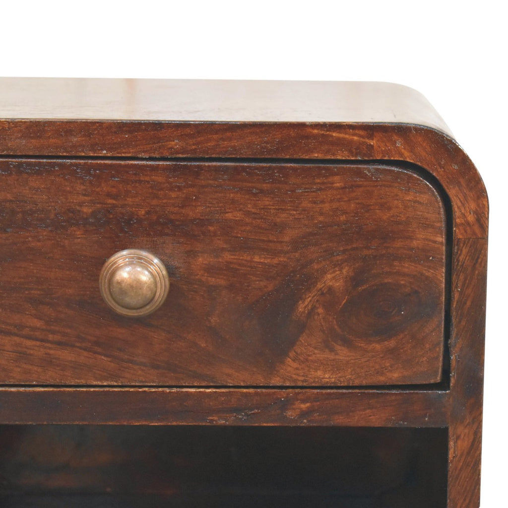 Close-up of the drawer knob and wood grain on a dark walnut brown wall-mounted bedside table